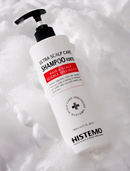 A bottle of Histemo Ultra Scalp Care Shampoo Forte with a black pump dispenser, set against a background of white foam or snow.